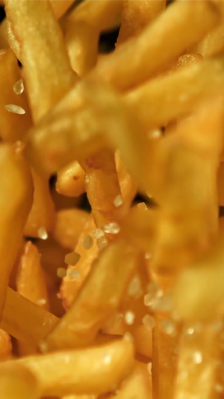 Slow Motion Shot of Salt Being Sprinkled on French Fries