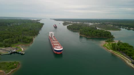 two cargo ships navigating a scenic waterway