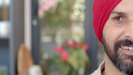 smiling man in red turban at home, enjoying relaxed moment