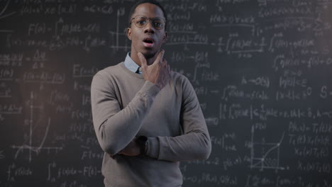man pondering mathematical equations on a chalkboard