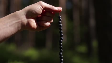 Mano-Sosteniendo-Arándanos-Recogidos-En-Un-Bosque-Sueco-Apilados-En-Una-Paja-Colgando