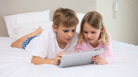 hermanos alegres usando una tableta