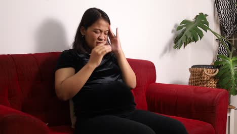 asian pregnant woman having headache at home