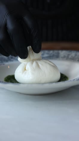 chef preparing burrata with pesto