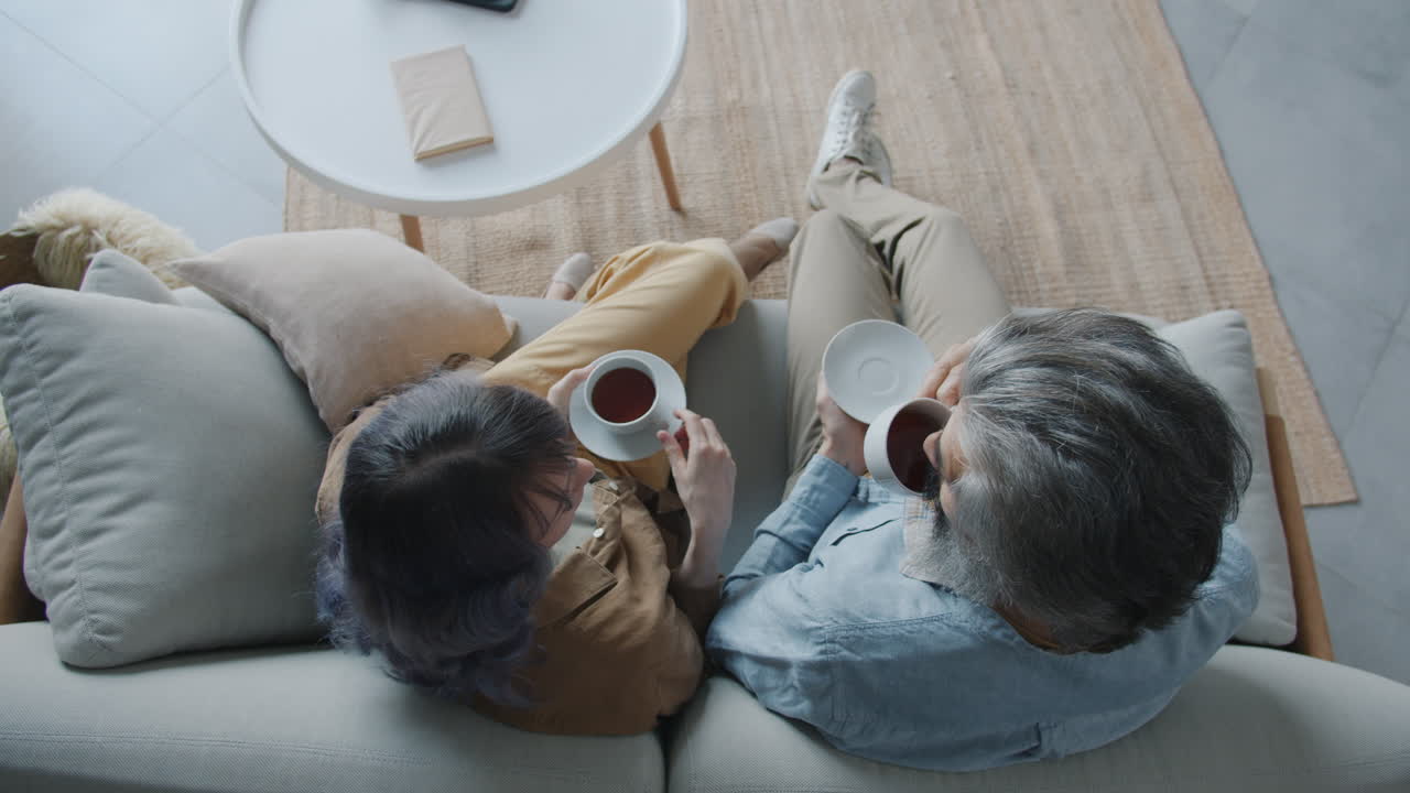 Couple Relaxing on Sofa with Tea