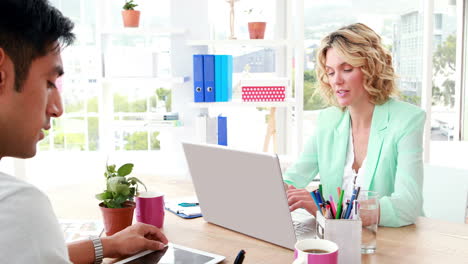 Business-colleagues-working-on-laptop-and-tablet