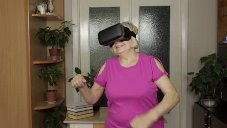Woman-in-VR-goggles-dancing,-having-fun.-Grandmother-in-virtual-headset-watching-amazing-3D-video