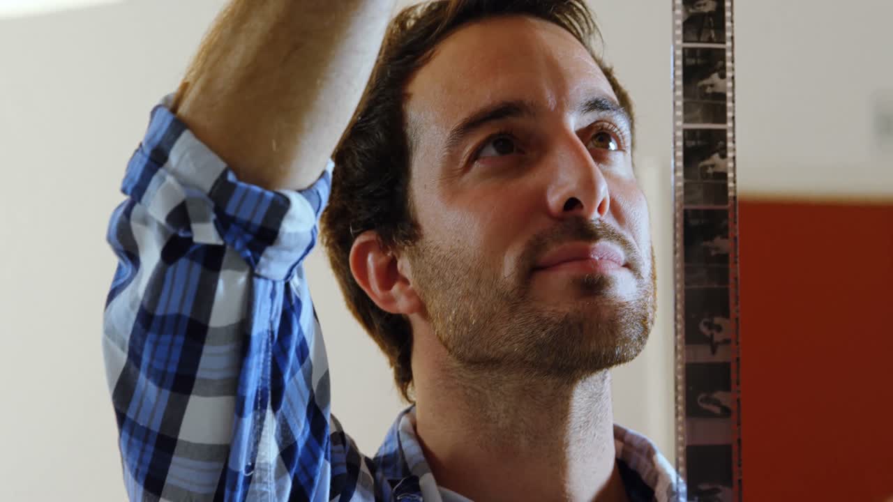 fotógrafo masculino comprobando las películas negativas 4k