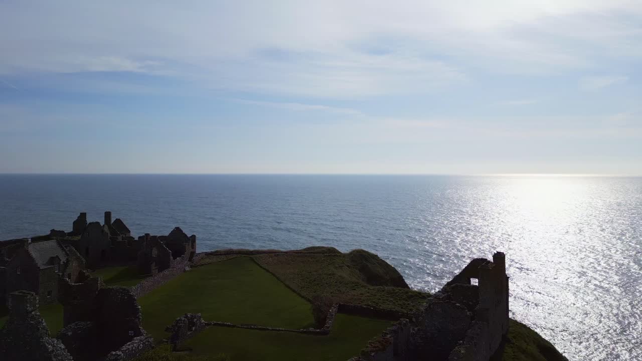 viaje aéreo hacia y sobre el magnífico castillo de dunnottar en escocia con vistas al vasto océano que se extiende más allá