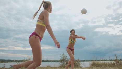 Junge-Frauen-Spielen-Am-Strand-Volleyball.-Profispielerinnen-Trainieren-Springen-Und-Passen-Des-Balls