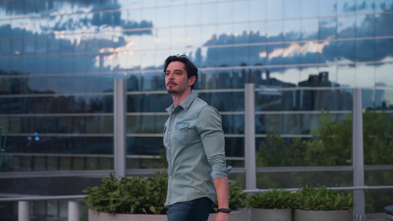 Ritratto di un uomo affascinante in camicia di jeans in un contesto urbano