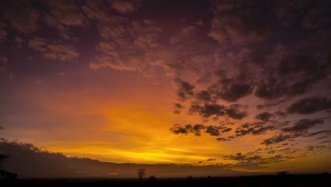 impresionante lapso de tiempo del amanecer sobre llanuras africanas con montañas y cielo rojo, nubes iluminadas