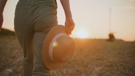 woman walking in a field at sunset