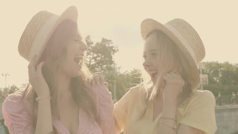 two happy friends wearing straw hats and laughing