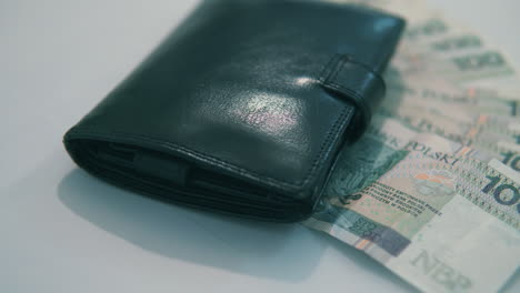 pan from right to left: 100 polish zloty under black wallet