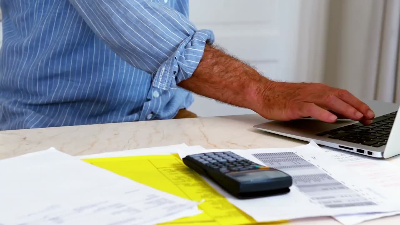 hombre mayor usando una computadora portátil en casa