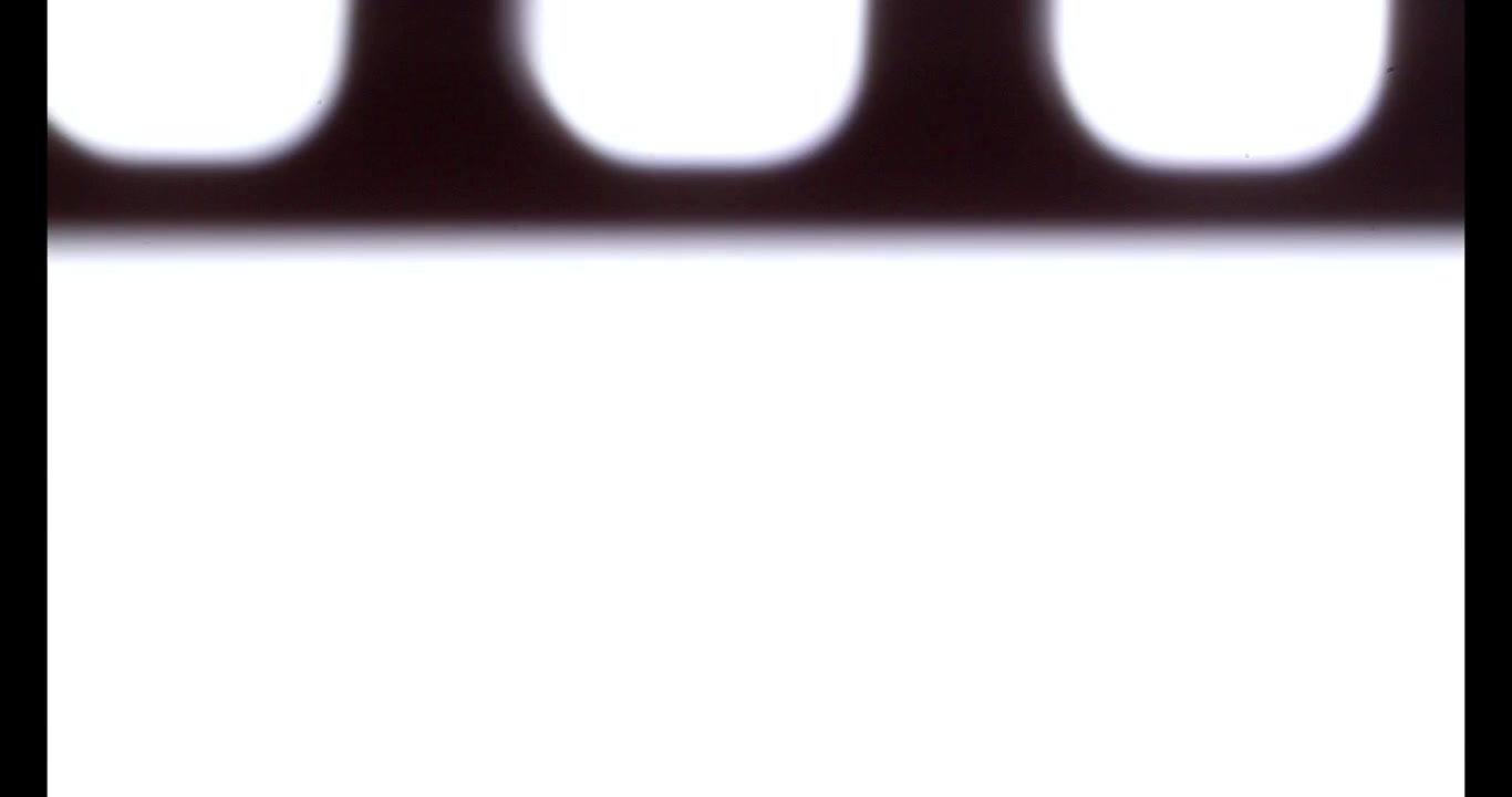 Close-up of 35mm Film Strip Moving Through Projector