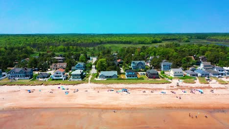 drone aerial of a beautiful maine seaside cottage. spacious deck, panoramic ocean views, sandy yard, and big windows create a stunning real estate opportunity for vacation or family living.