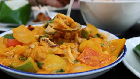 un plato de curry tailandés vibrante que se sirve a mano