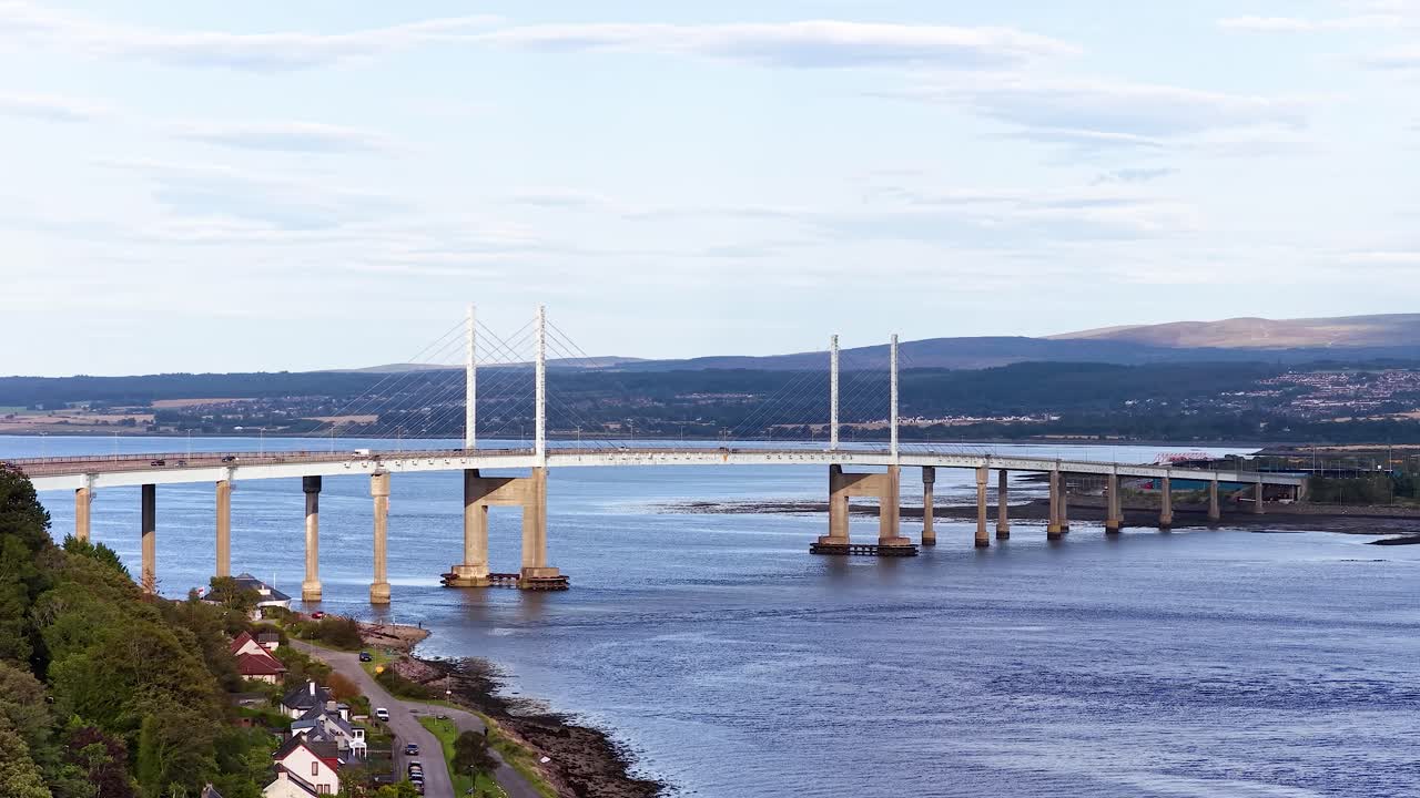 Daytime aerial pan reveals modern bridge, river, and rural landscape in Fife, Scotland
