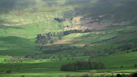 Cloud-shadows-moving-over-hillside-and-small-woodland-in-English-countryside-springtime-countryside