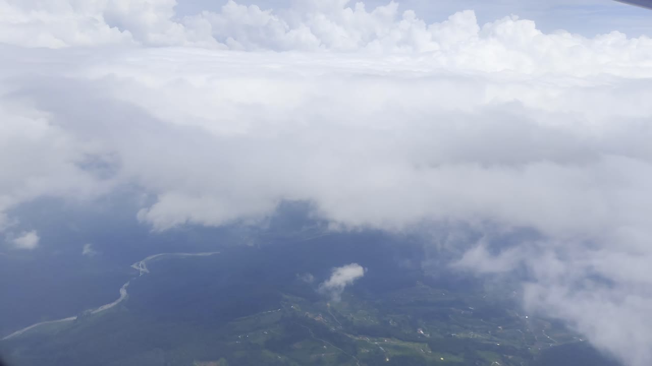 Footage of white clouds and sky in motion, captured from an airplane. Perfect for travel, aerial views, and nature projects, showcasing serene skies and dynamic movement above the landscape