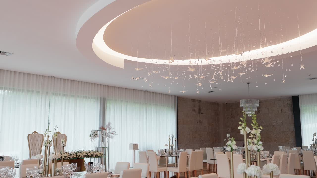 luxurious wedding reception space with floating crystal birds and soft natural window light