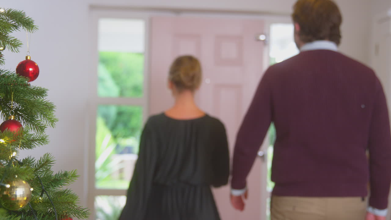 크리스마스 를 축하 하기 위해 선물 을 가지고 도착 하는 노인 부모 들 을 인사 하는 부부