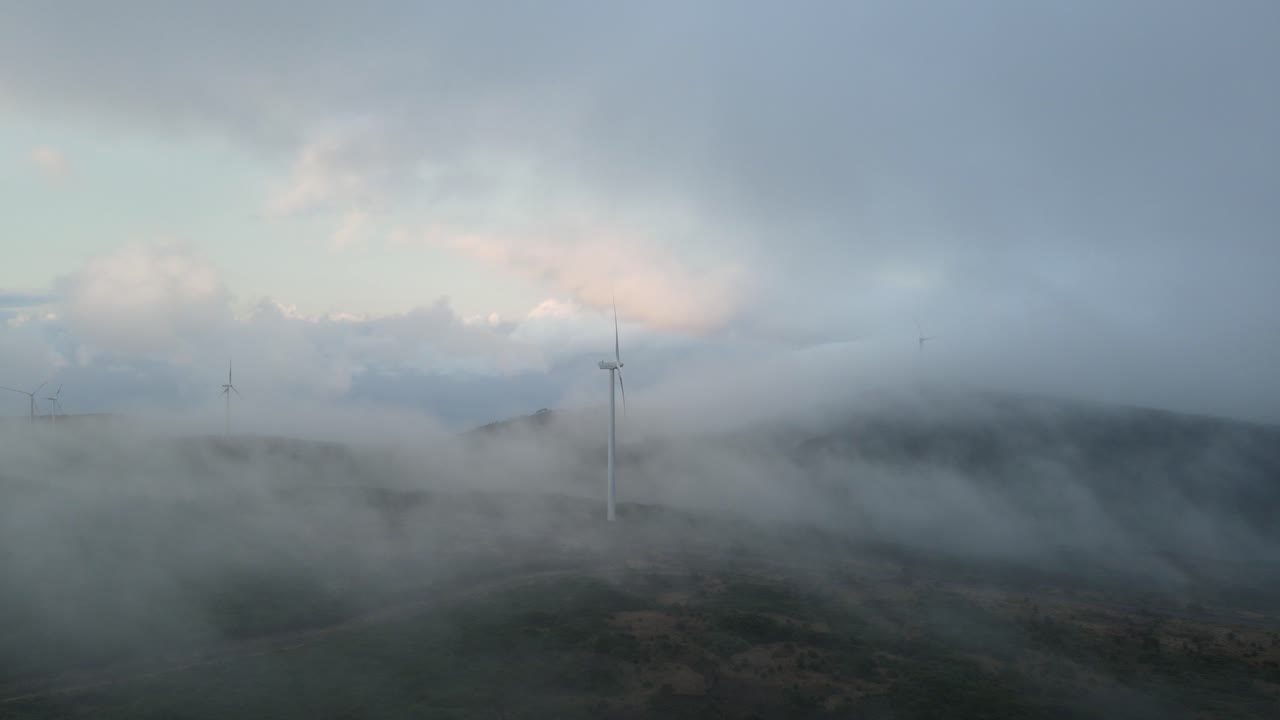 산 위의 풍력 터빈은 푸른 에너지를 생산하고, 하늘에는 구름으로 둘러싸여 있습니다.