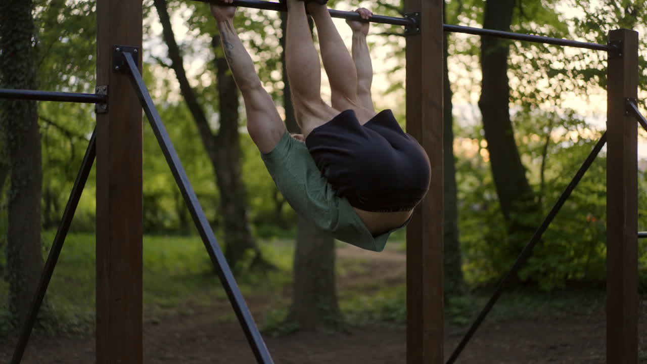 Man exercising on pull-up bar in the park