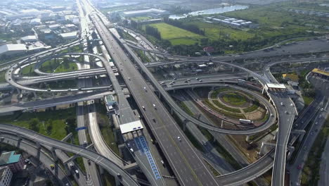 aerial view of highway road interchange with busy urban traffic speeding on road