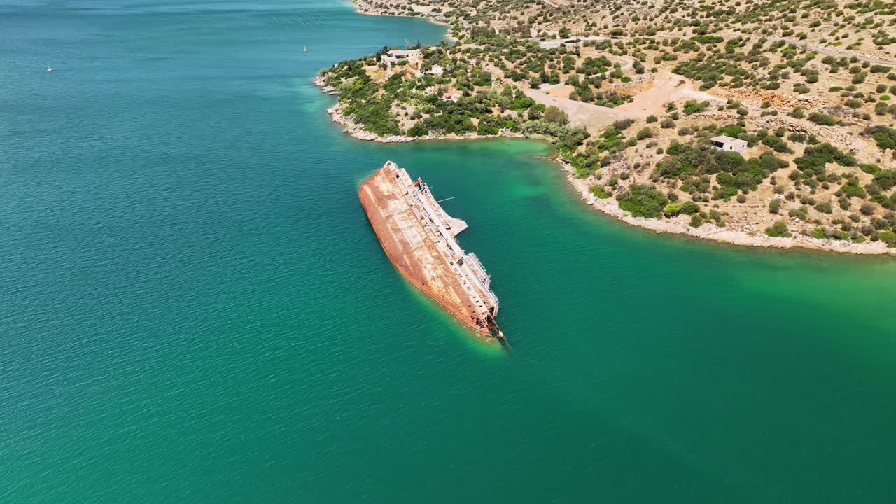 Flyover shot of the Mediterranean Sky showing surrounding vegetation and rocky hills meeting the vibrant Aegean waters.