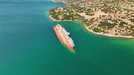 flyover shot of the mediterranean sky showing surrounding vegetation and rocky hills meeting the vibrant aegean waters.