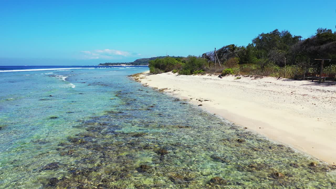 Clear crystal water on seashore of tropical island washing white sand of exotic beach on a shiny day with bright blue sky background in Jamaica