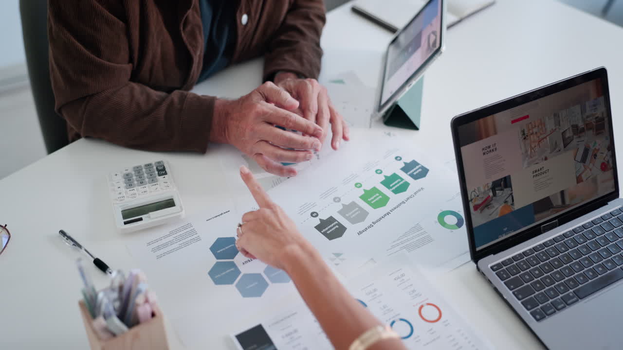 Business Professionals Discussing Strategy and Data on Office Desk