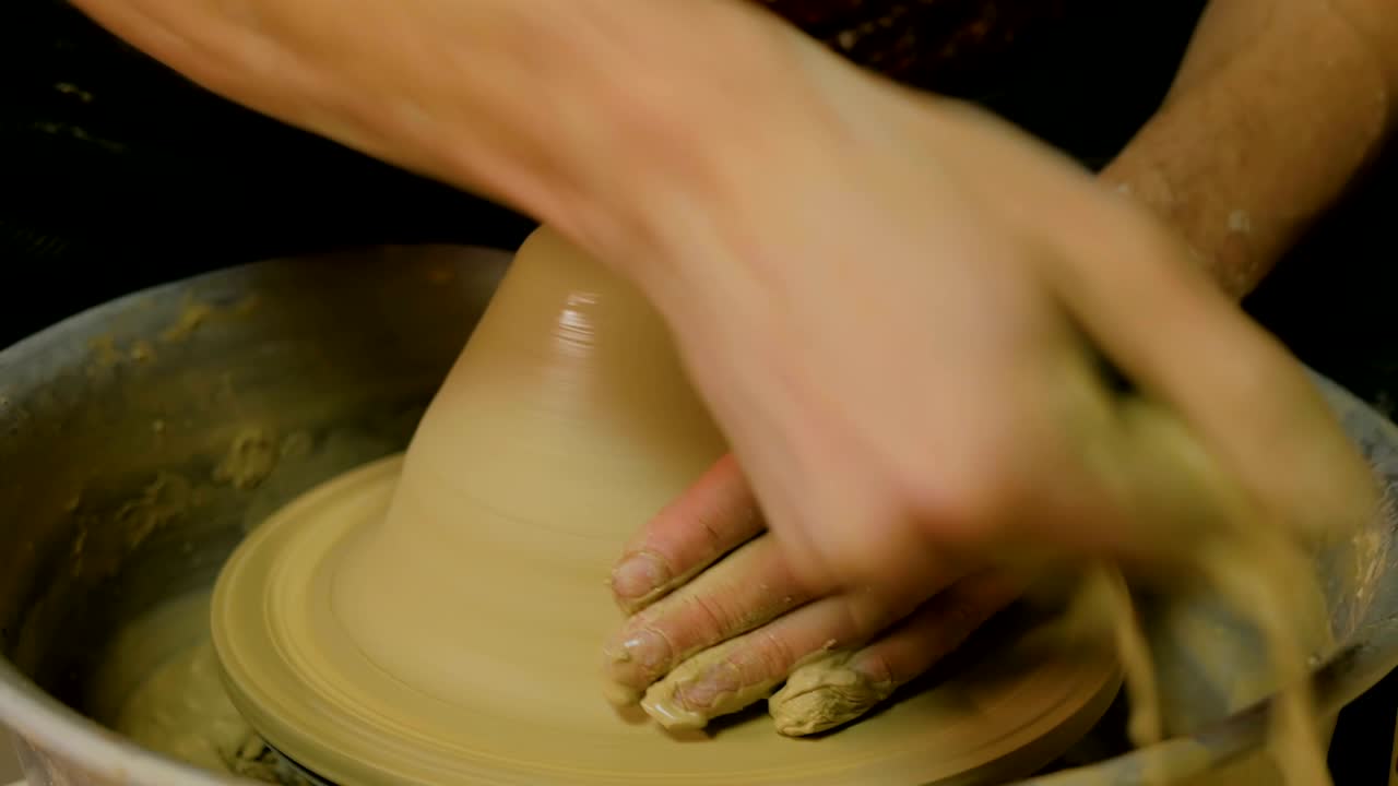 un alfarero profesional que trabaja con arcilla en la rueda del alfarero
