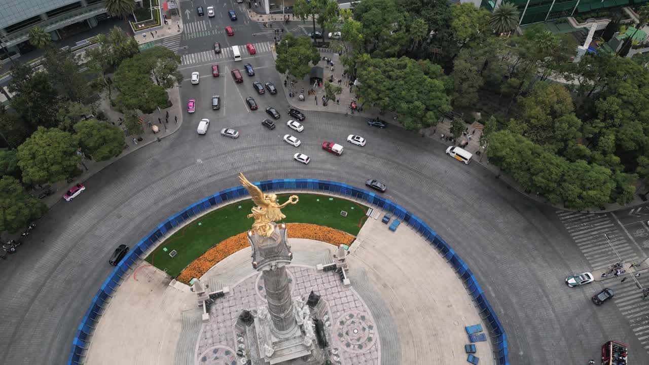 los coches pasan por el paseo de la reforma y la rotonda donde se encuentra el monumento del ángel de la independencia