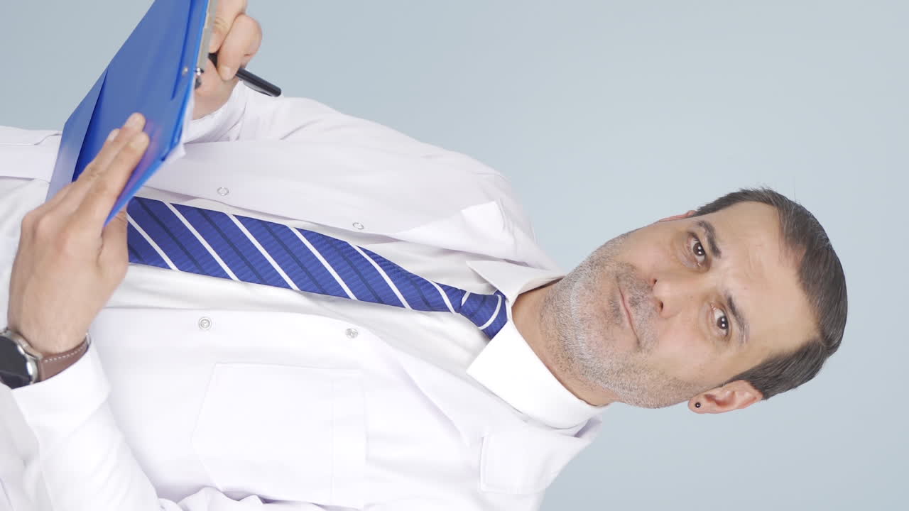 정신과 의사가 메모를 하는 수직 비디오입니다.