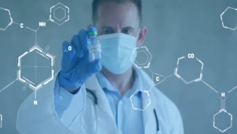 animation of chemical structures over caucasian male doctor holding vaccine wearing face mask