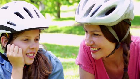 mother and daughter having a break on their bike ride in the park
