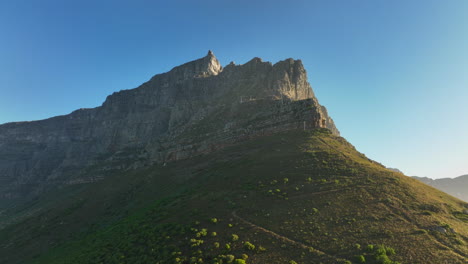 Vista-De-ángulo-Bajo-De-Altas-Paredes-Rocosas-Empinadas-En-La-Montaña-De-La-Mesa.-Volar-Sobre-El-Paisaje-En-El-Parque-Nacional-En-Un-Día-Soleado.-Ciudad-Del-Cabo,-Sudáfrica