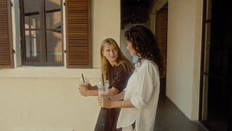 two women enjoying drinks outside