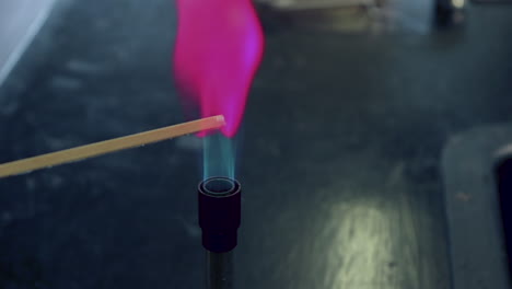 Close-up-of-blue-bunsen-burner-flame-followed-by-lithium-flame-test-burning-magenta