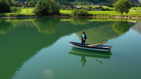 woman on the boat catches a fish on spinning in norway.