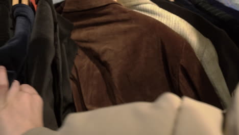 Close-Up-Of-a-Woman-Hands-Choosing-clothes-in-a-Thrift-shop