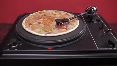 a pizza spins on a turntable like a vinyl record, blending music and food into a playful visual twist