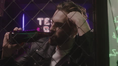 sad man sitting at disco club and drinking beer