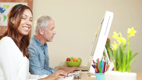 Smiling-casual-businesswoman-showing-work-to-colleague