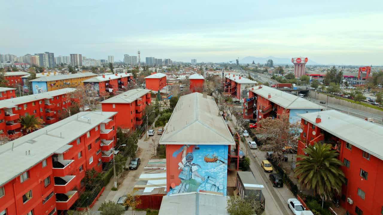 Flyover revealing tilt up of the residential blocks of the San Miguel open air museum, children playing soccer, Santiago de Chile