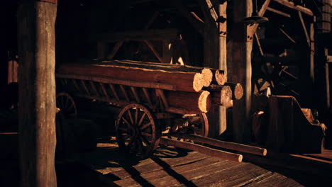 a wooden cart filled with logs in a rustic barn